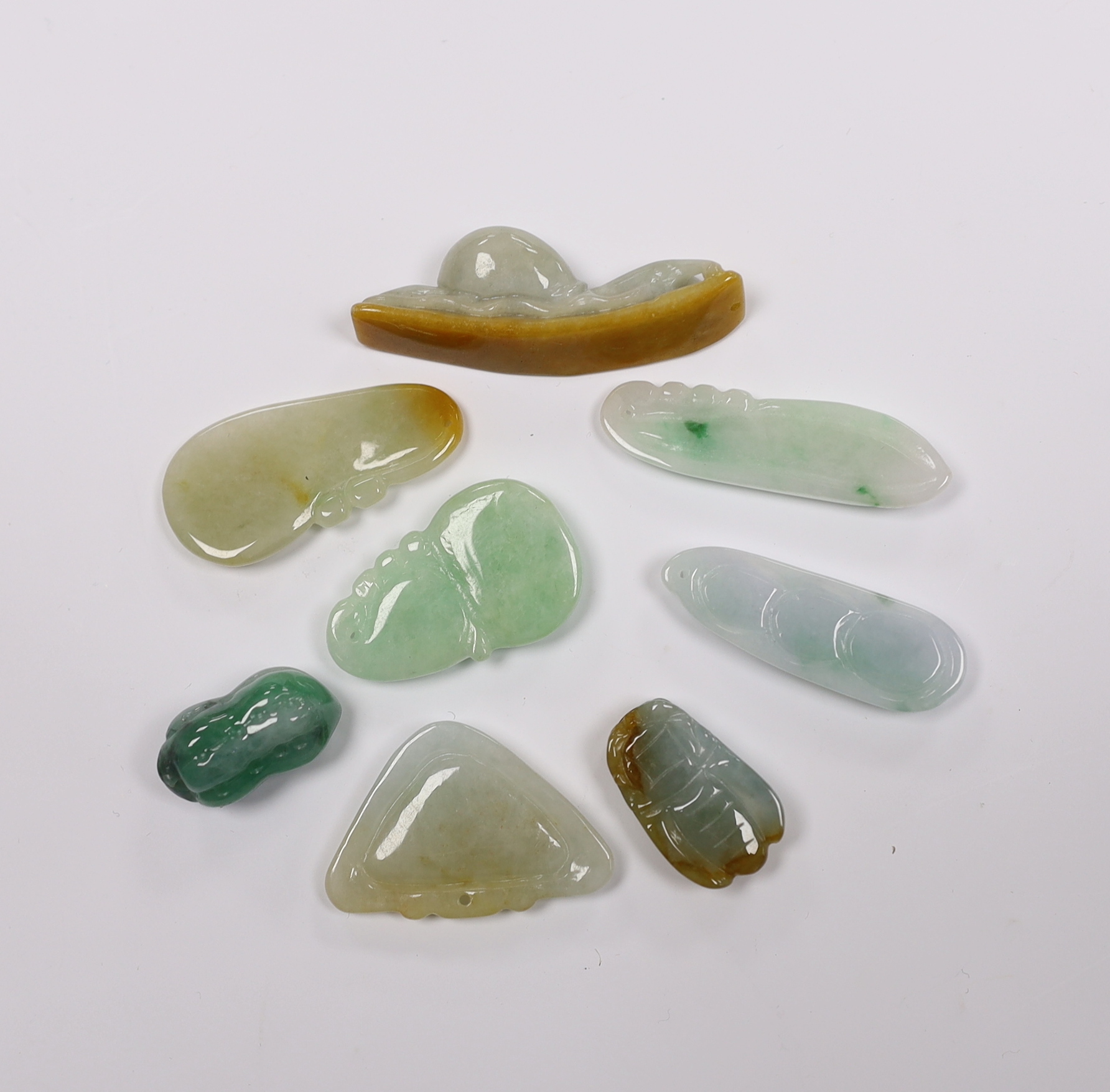 Eight various Chinese carved jadeite pendants